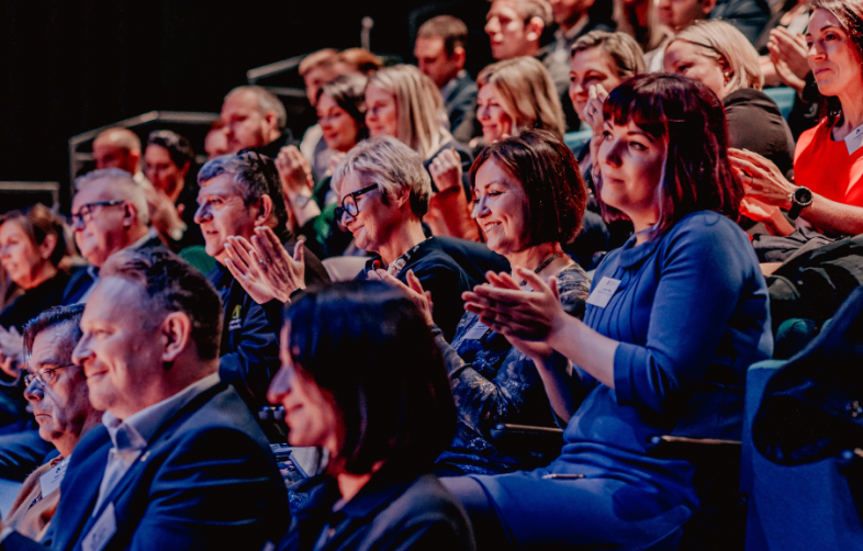 Audience members clapping and looking happy