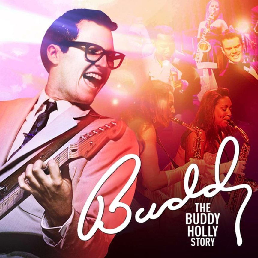 A vibrant image featuring a smiling musician in glasses and a suit playing guitar, surrounded by a colourful, energetic stage scene. Text reads “Buddy: The Buddy Holly Story.”