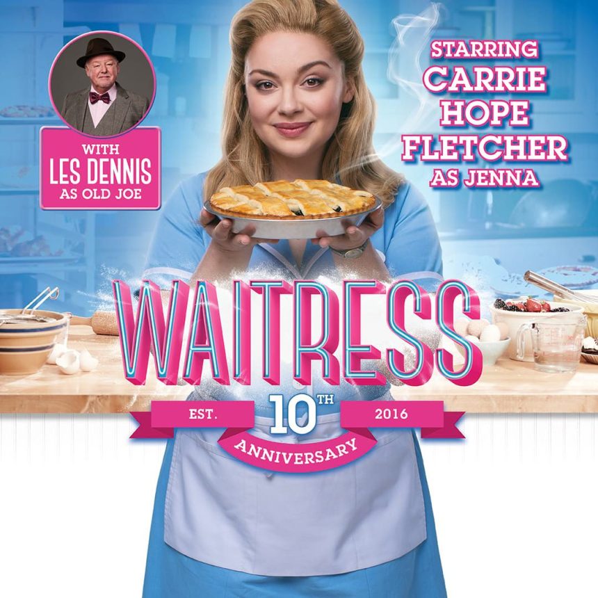 Actress in a blue waitress uniform holds a pie in a kitchen setting, promoting the "Waitress" musical's 10th anniversary. Playful and inviting tone.